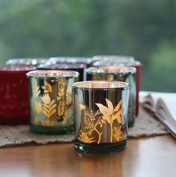 Laser-engraved botanical pattern on mirrored glass votives